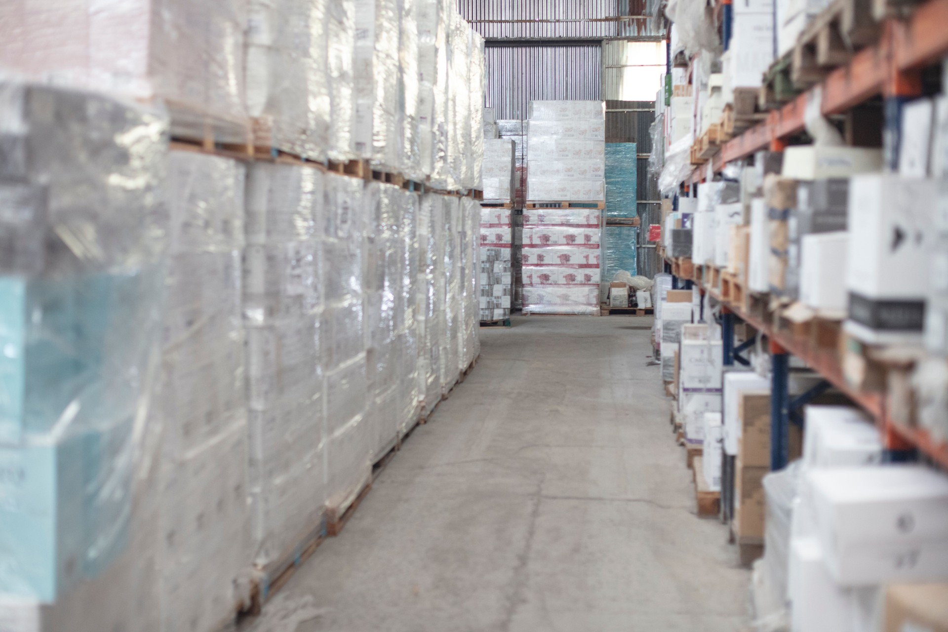 Empty distribution warehouse aisle full of stacked pallets